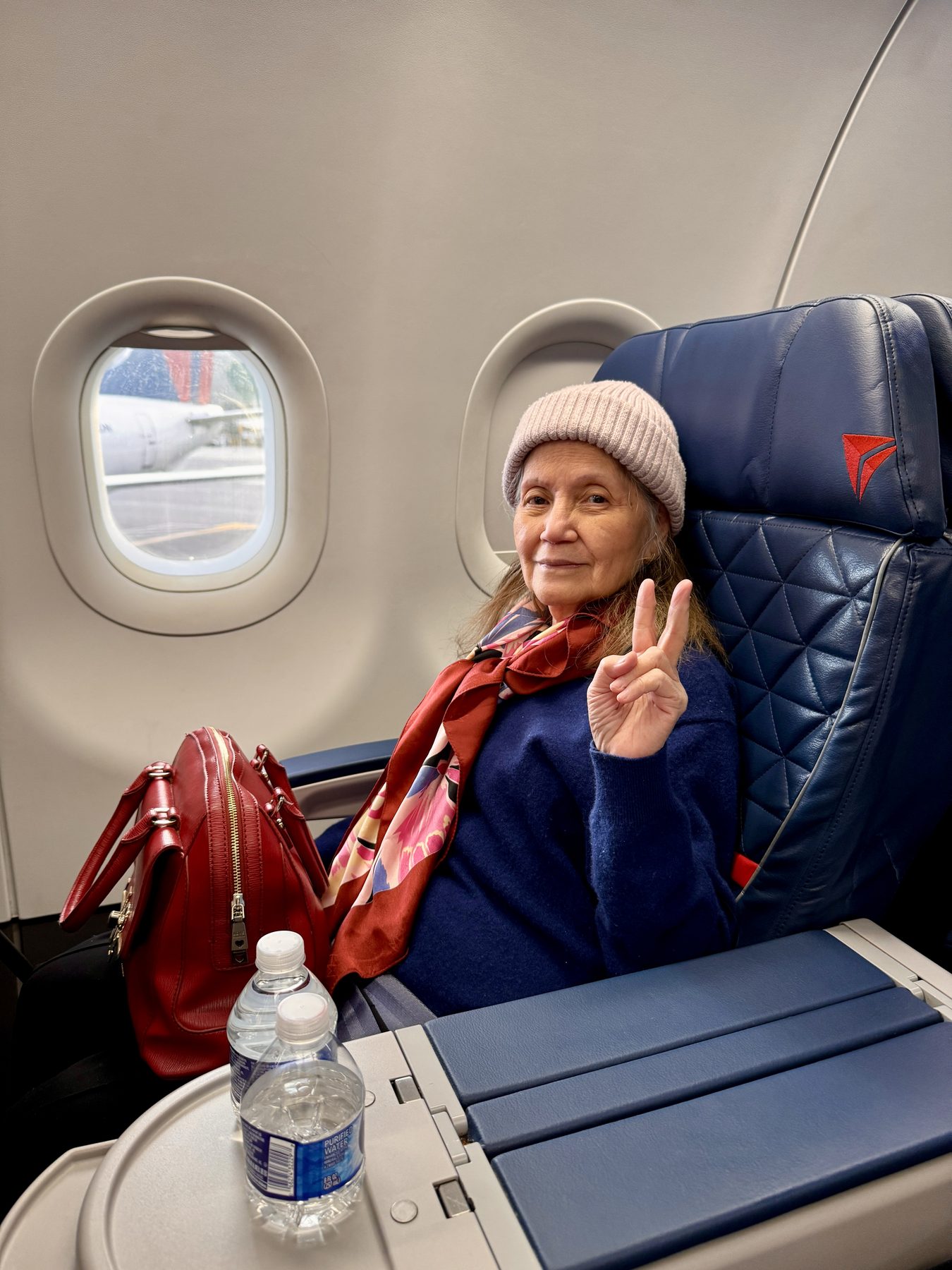 Connie on a flight, giving a peace sign