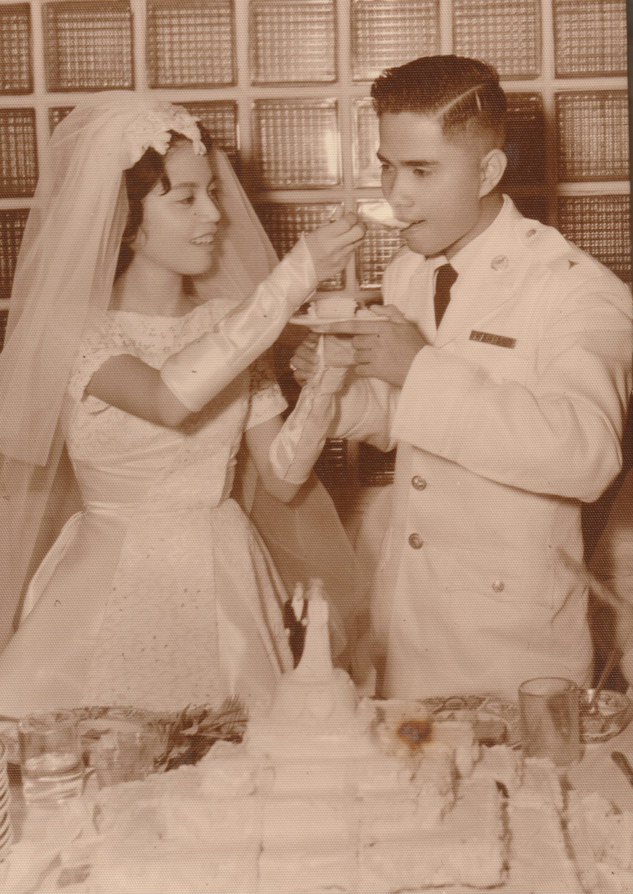 Connie and Carlos Mariano beneath a sword arch